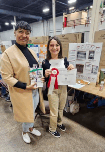 Alexia Riche presents a special prize from the PEI Advisory Council on the Status of Women to a youth at the 2025 Provincial Heritage Fair
