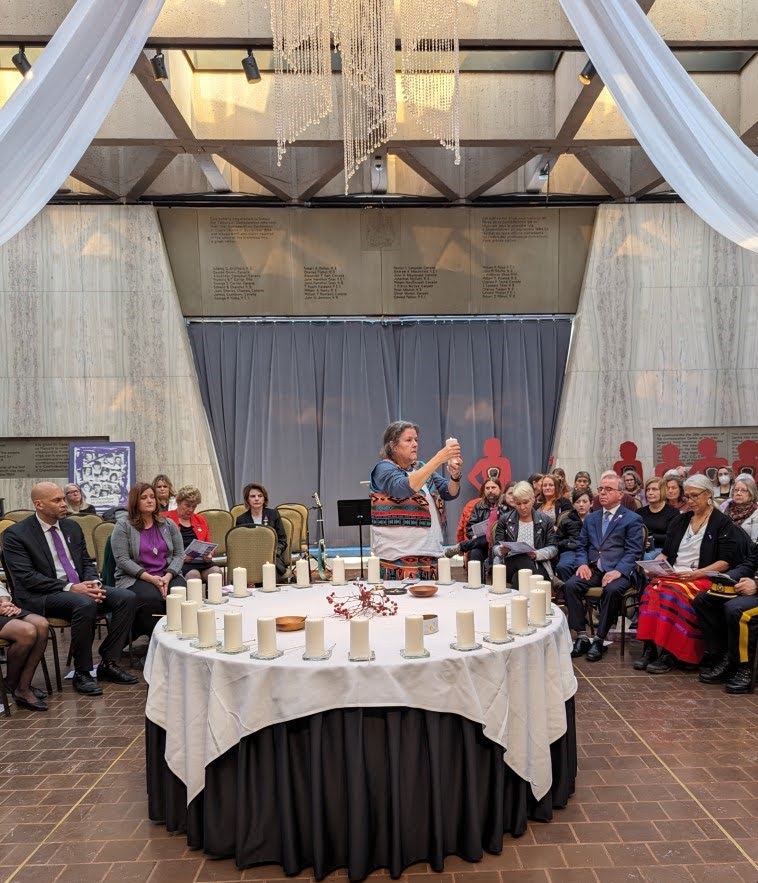 Elder Thirly Levi raises a candle in prayer at the 2023 Montreal Massacre Memorial Service.